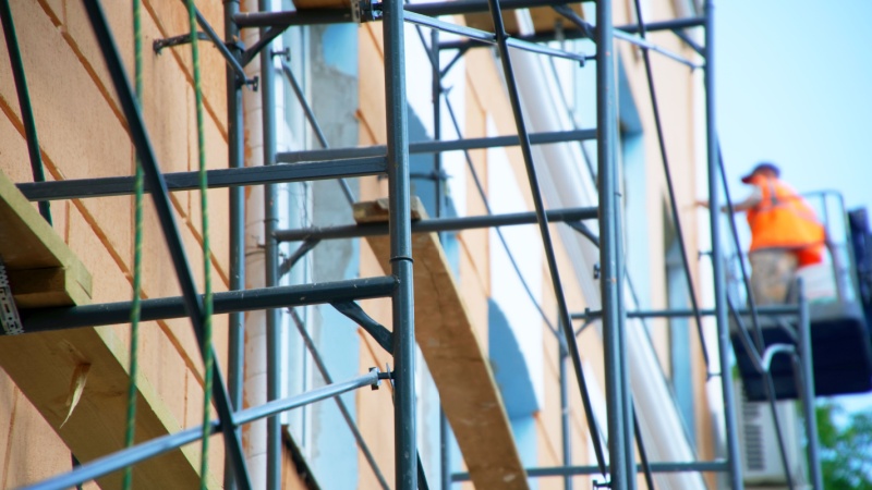 Impalcature su edificio con operaio sul ponteggio